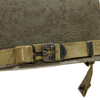 Coque de casque en version Battle Battered du 502nd PIR et son grade de 1st Lt en métal colé à l'avant du casque. Gros plan de la jugulaire version parachutiste fixée à l'arrière du casque.