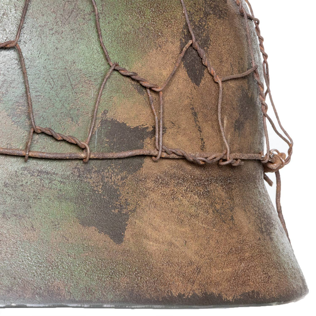 Gros plan du cerclage du grillages à poules du casque M40 Battle Battered camouglage 2 tons Normandie