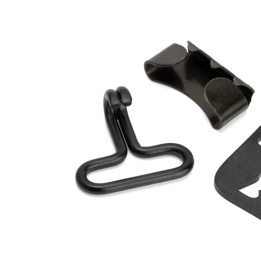 Crochet et embout d'extrémité de la jugulaire M1, montrant la finition noire par oxydation ou peinture.